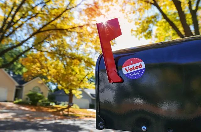 Rural mailbox with I voted today sticker and raised carrier signal flag